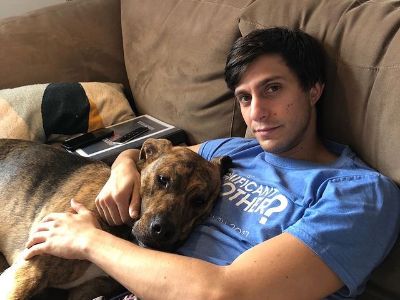 Gideon Glick is lying on the couch with Truman.